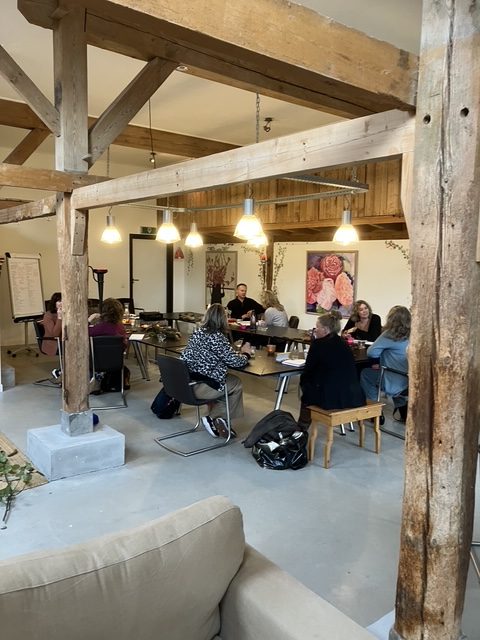 Training voor ondernemers: deelnemers aan tafel in een ruimte met houten balken